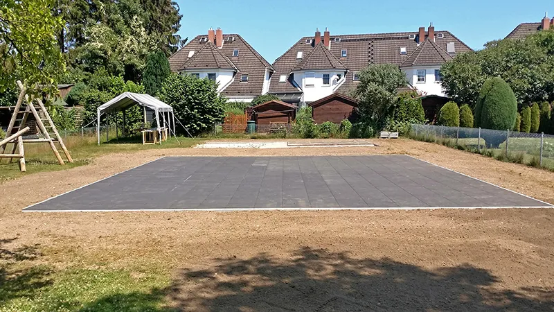 L’ampio campo sportivo multifunzionale con il pavimento grigio in gomma WARCO per l'utilizzo dai residenti del quartiere residenziale.