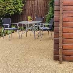 Die Terrasse eines Ferienhauses fügt sich durch die natürlich wirkenden beige-braunen Terrassenplatten ideal in die Umgebung ein und schafft eine harmonische Verbindung zwischen Ferienhaus und Garten. In der Fläche ist die Puzzleverzahnung an den Plattenrändern durch das strukturierte Farbdesign kaum sichtbar. Die Puzzleverzahnung verbindet die einzelnen Platten zu einer lagestabilen Plattenfläche. Daher wird dieser Terrassenbelag nicht mit dem Untergrund verklebt oder verschraubt. Die trittelastischen, vollflächig wasserdurchlässigen und rutschhemmenden Terrassenplatten isolieren gegen Bodenkälte und bieten Komfort zu jeder Jahreszeit.