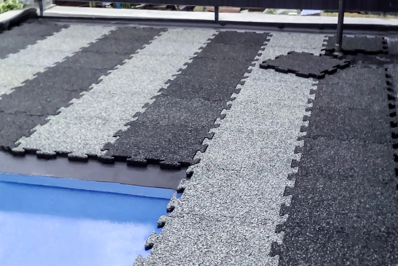 Una vecchia piscina in cemento nel giardino è in fase di ristrutturazione. Il bordo della piscina è rivestito con le piastrelle WARCO in Granito chiaro e scuro.